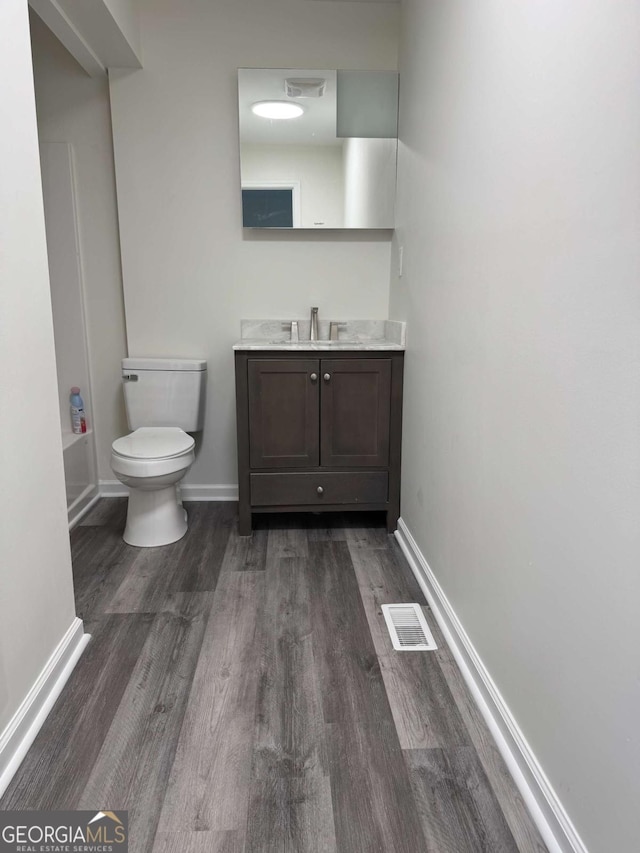 full bathroom featuring tub / shower combination, hardwood / wood-style flooring, toilet, and vanity