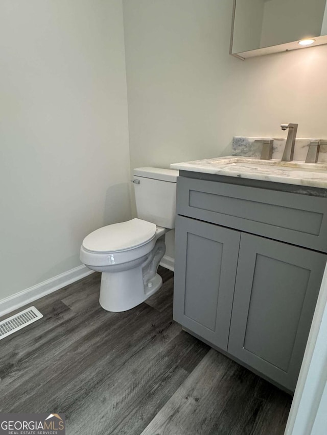 bathroom with vanity, hardwood / wood-style flooring, and toilet