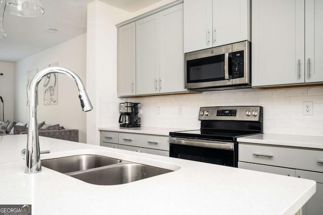 kitchen featuring sink, appliances with stainless steel finishes, gray cabinetry, and tasteful backsplash