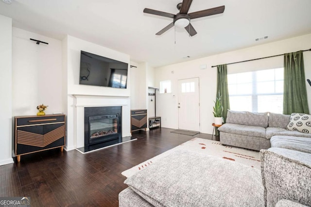 living room with dark wood-type flooring and ceiling fan