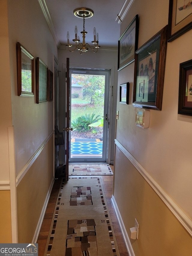 doorway to outside featuring an inviting chandelier and ornamental molding