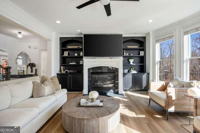 living room featuring hardwood / wood-style flooring, built in features, and a fireplace