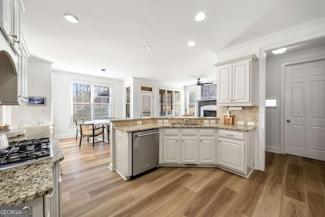 kitchen featuring white cabinets, backsplash, appliances with stainless steel finishes, and sink