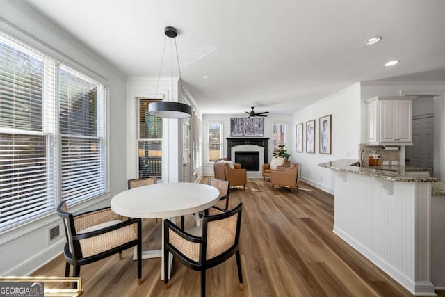 dining space with ceiling fan, dark hardwood / wood-style flooring, and crown molding