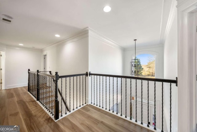 hallway featuring hardwood / wood-style flooring, a notable chandelier, and ornamental molding