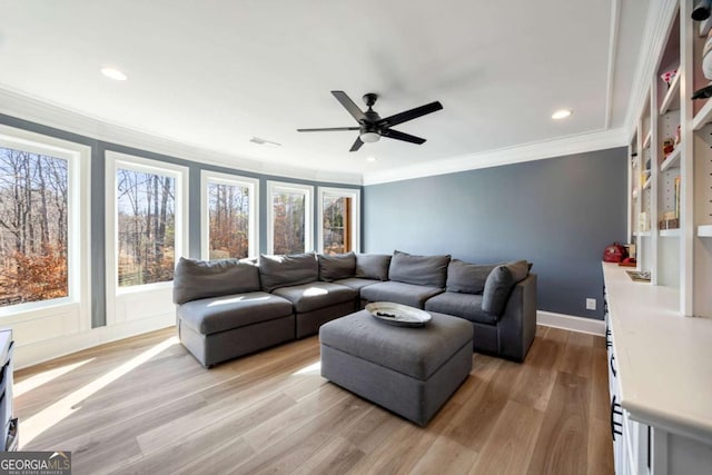 living room with ceiling fan, built in shelves, light hardwood / wood-style flooring, and crown molding