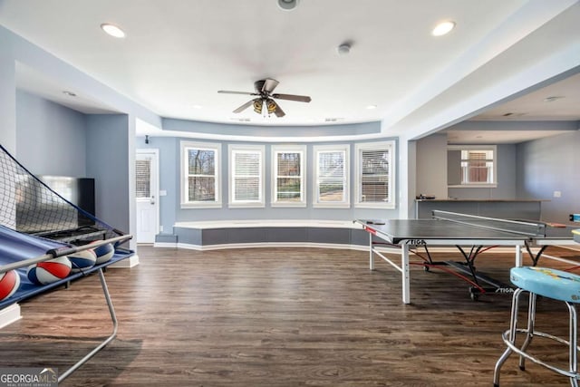 rec room with ceiling fan, a wealth of natural light, and dark hardwood / wood-style flooring