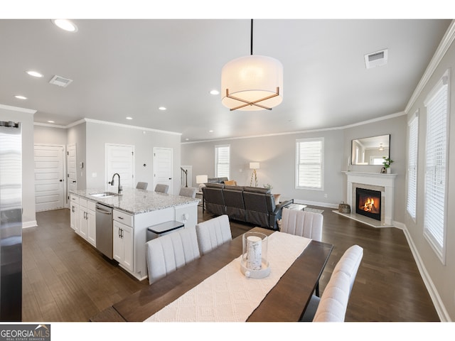 dining space featuring sink, crown molding, and dark hardwood / wood-style floors