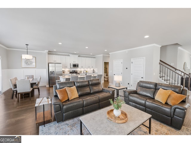 living room with sink, hardwood / wood-style flooring, and ornamental molding