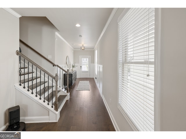 foyer with ornamental molding and dark wood-type flooring