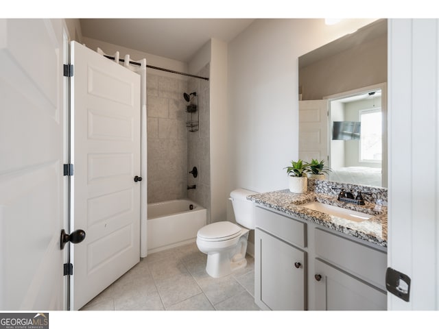 full bathroom featuring tiled shower / bath combo, vanity, toilet, and tile patterned flooring