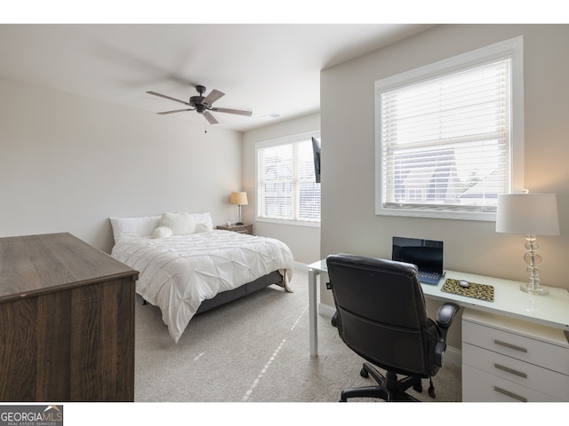 carpeted bedroom with multiple windows and ceiling fan