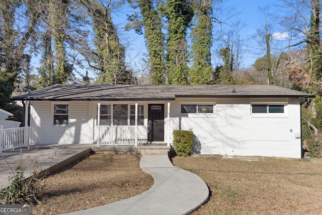 ranch-style house with a front yard and covered porch