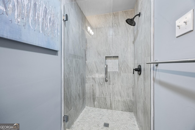 bathroom featuring a shower with shower door