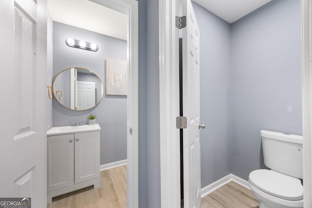 bathroom featuring vanity, hardwood / wood-style flooring, and toilet