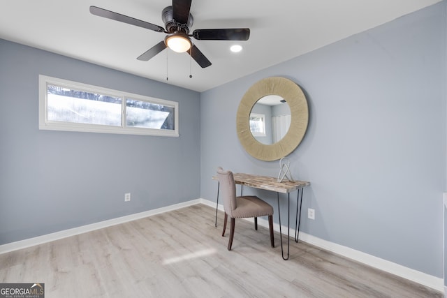 office with light hardwood / wood-style flooring and ceiling fan