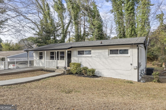 single story home featuring cooling unit, a front yard, and a porch