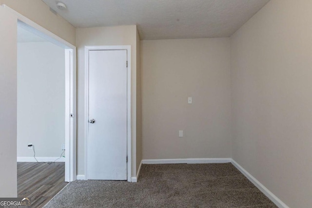 carpeted empty room with a textured ceiling