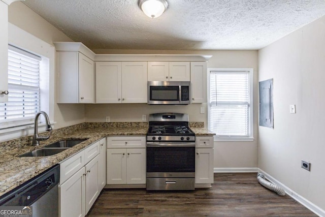 kitchen with sink, stainless steel appliances, white cabinetry, and light stone countertops