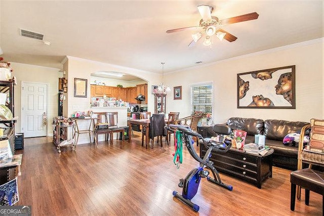 workout area featuring crown molding, ceiling fan, and light wood-type flooring