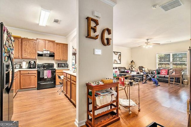 kitchen featuring ventilation hood, ornamental molding, light hardwood / wood-style floors, and black range with electric cooktop