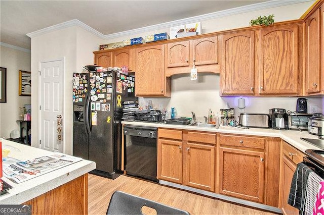 kitchen featuring ornamental molding, light wood-type flooring, and black appliances