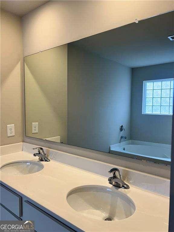 bathroom with a tub and vanity