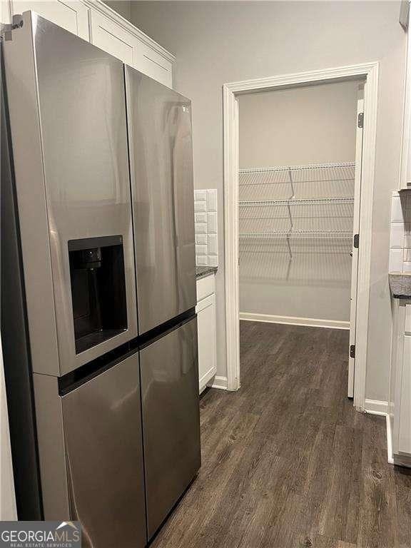 kitchen featuring stainless steel refrigerator with ice dispenser, white cabinets, and dark hardwood / wood-style flooring