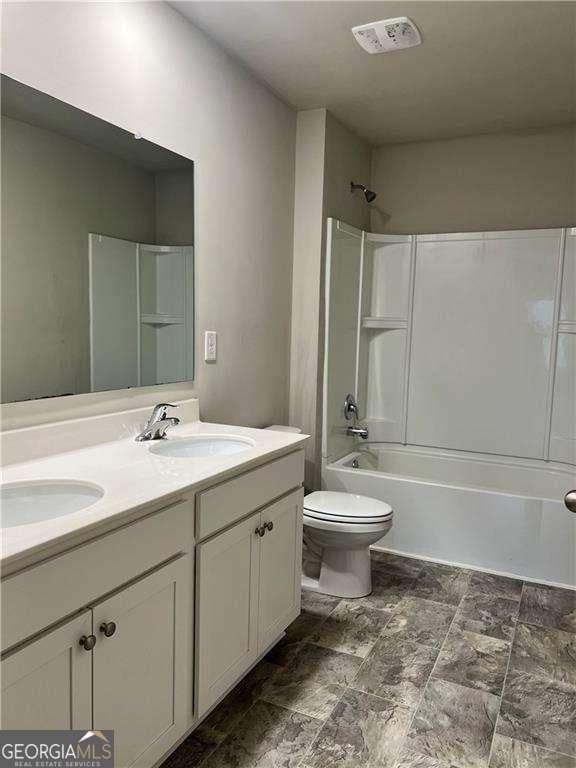 full bathroom featuring toilet, vanity, and  shower combination