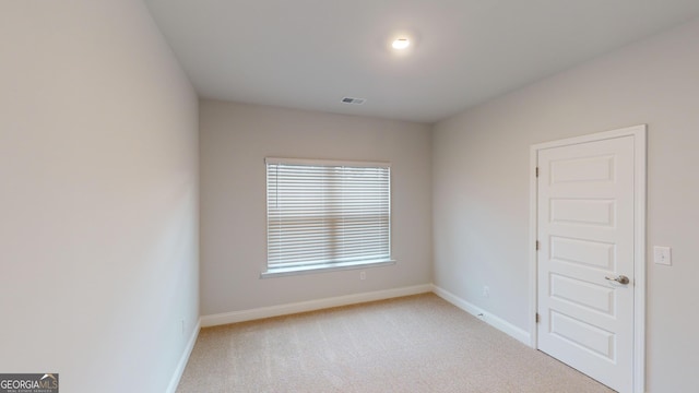 spare room featuring light carpet