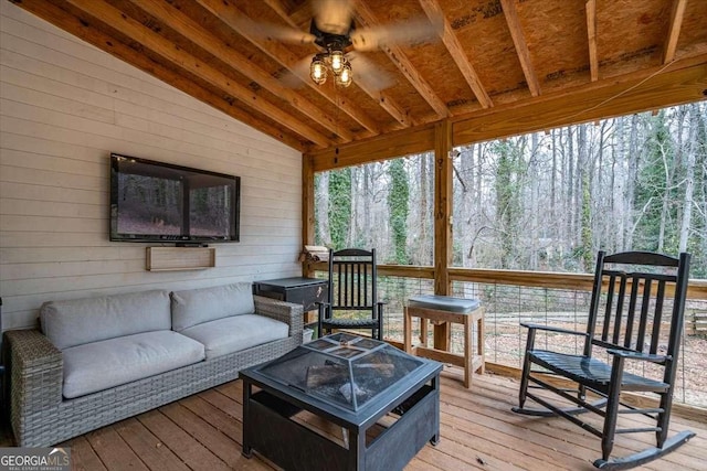 wooden deck featuring an outdoor living space with a fire pit