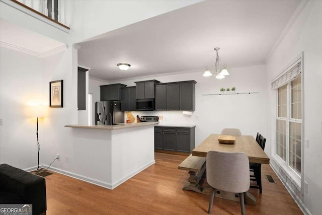 kitchen with light hardwood / wood-style floors, kitchen peninsula, appliances with stainless steel finishes, and crown molding