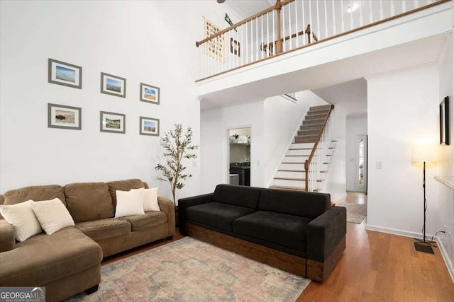 living room featuring hardwood / wood-style flooring and a high ceiling