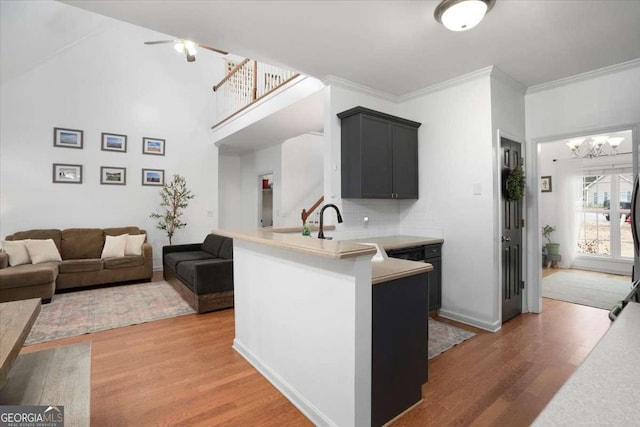 kitchen featuring kitchen peninsula, backsplash, dark wood-type flooring, and crown molding