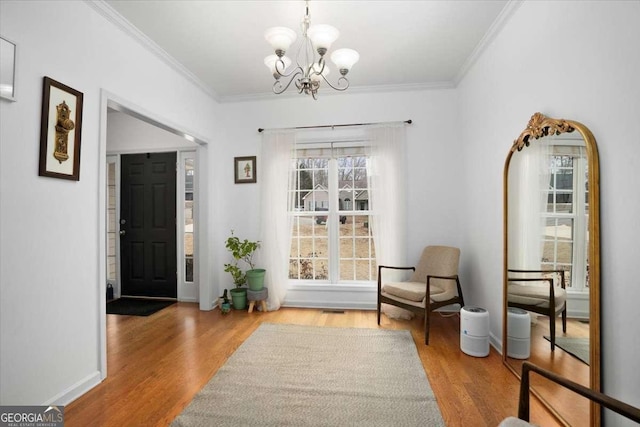 entrance foyer featuring crown molding, light hardwood / wood-style floors, and a notable chandelier