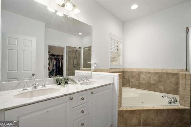 bathroom featuring vanity and independent shower and bath