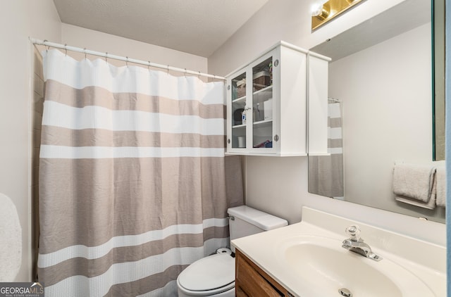 bathroom with vanity, a textured ceiling, and toilet