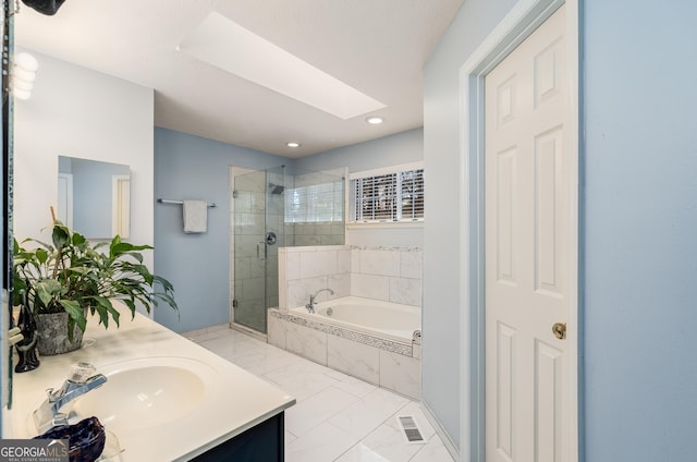 bathroom with vanity, a skylight, and independent shower and bath