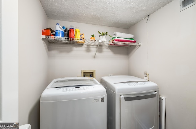 washroom featuring separate washer and dryer and a textured ceiling