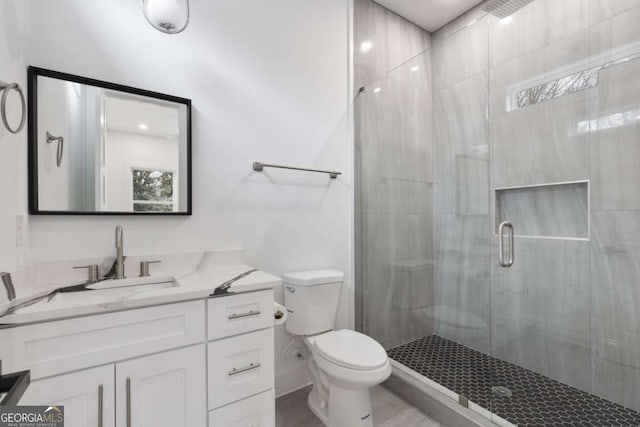 bathroom with vanity, toilet, and a shower with door