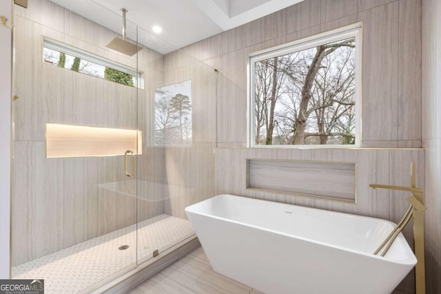 bathroom with tile walls and plus walk in shower