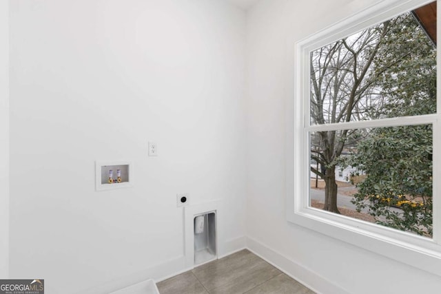 washroom featuring hookup for an electric dryer, hookup for a washing machine, and light tile patterned floors