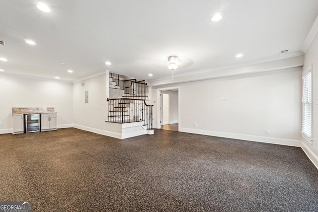 unfurnished living room with wine cooler, bar area, and crown molding