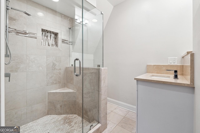 bathroom with an enclosed shower, vanity, and tile patterned flooring