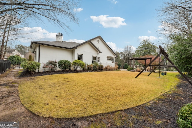 back of house featuring a pergola and a lawn