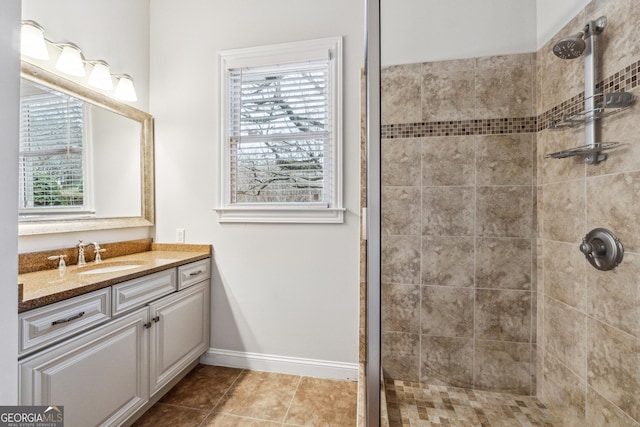 bathroom featuring vanity, tile patterned flooring, and a tile shower