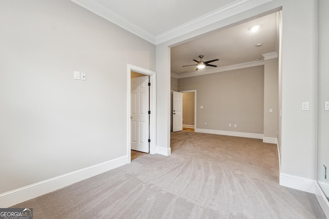 carpeted spare room featuring crown molding and ceiling fan