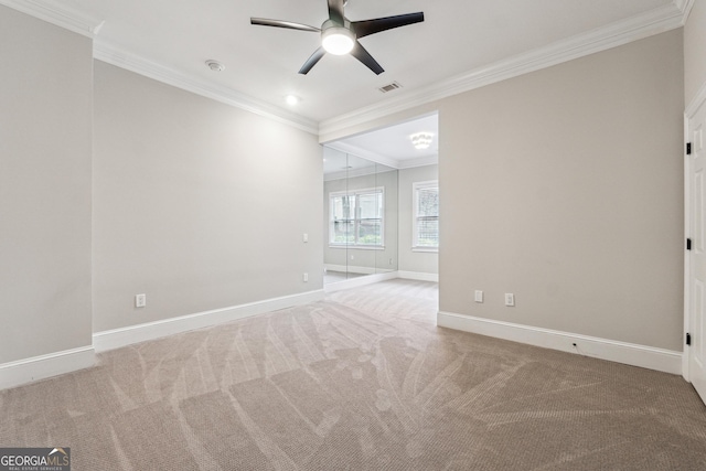 carpeted spare room featuring ornamental molding and ceiling fan