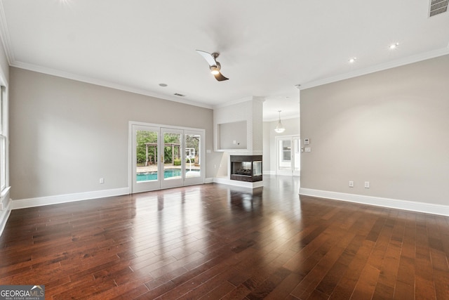 unfurnished living room with crown molding, dark wood-type flooring, and a multi sided fireplace