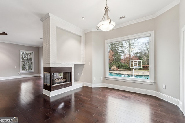 unfurnished living room featuring dark wood-type flooring, ornamental molding, and a fireplace